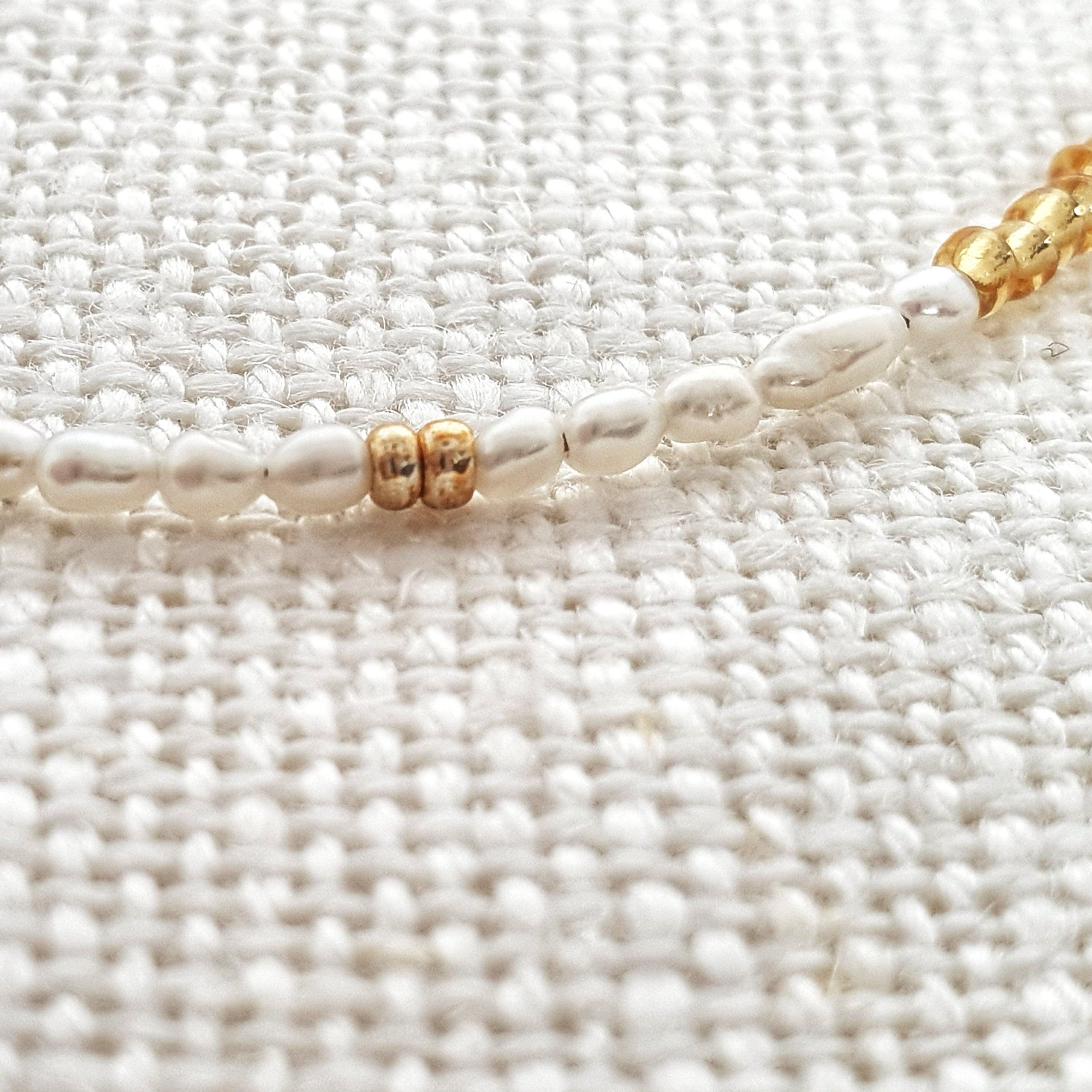 Designed with freshwater rice pearls, glass seed beads and 14Kt gold-filled beads. A dainty yet luxe piece featuring tiny pearls adorned by accents of gold. Stack this together with another minimal design for a delicate, feminine feel.