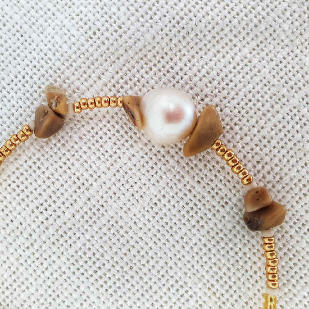 Designed with freshwater pearl, bamboo coral, glass seed beads and 14Kt gold-filled beads. Solo features a stunning large pearl, complimented by bamboo coral. A stand-out piece perfect on its own or part of a stack.