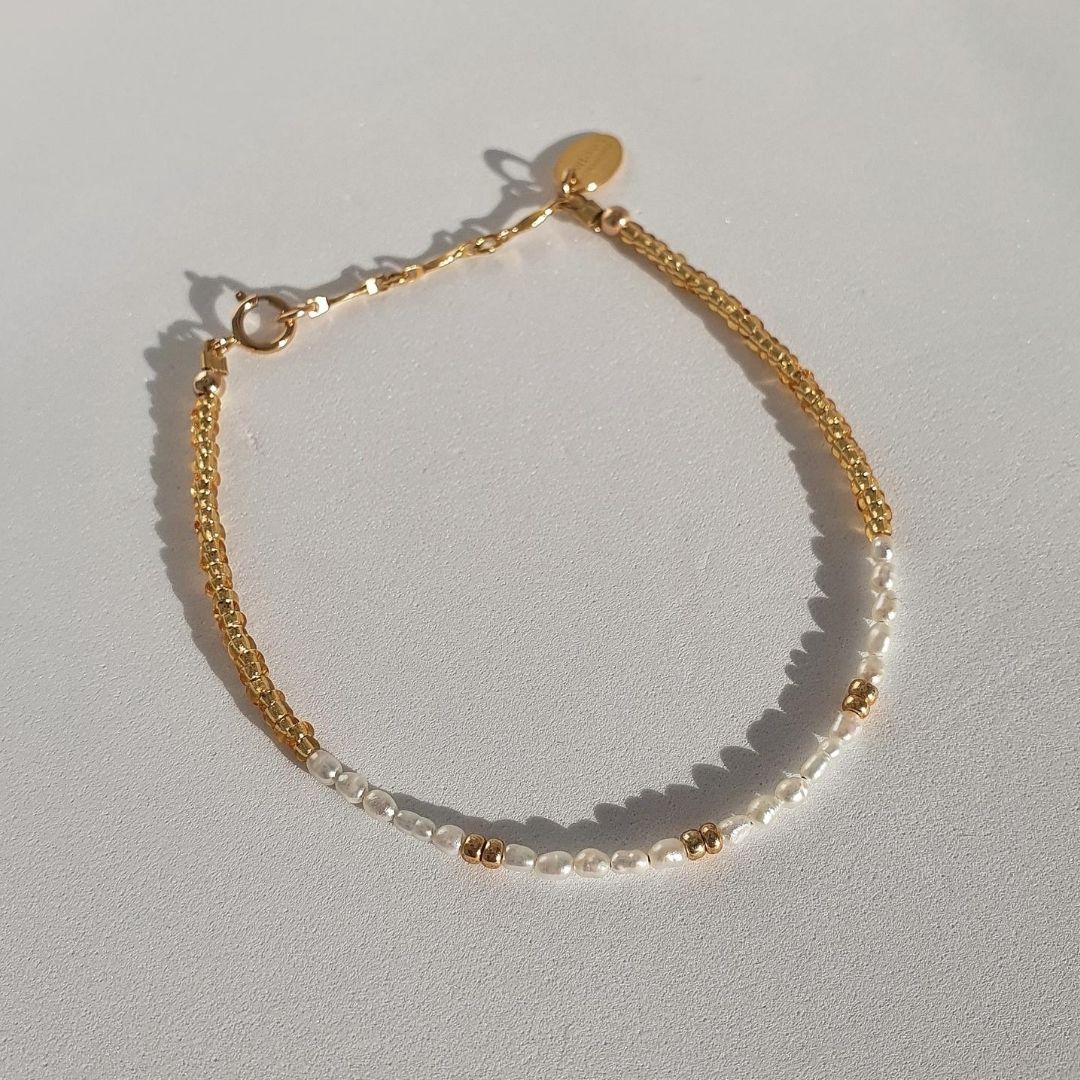 Designed with freshwater rice pearls, glass seed beads and 14Kt gold-filled beads. A dainty yet luxe piece featuring tiny pearls adorned by accents of gold. Stack this together with another minimal design for a delicate, feminine feel.